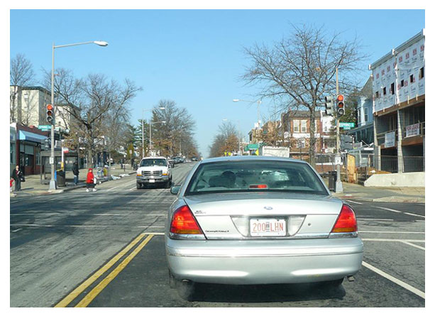 A Ford Crown Victoria registered with City Bicentennial plates stopped at a traffic light.