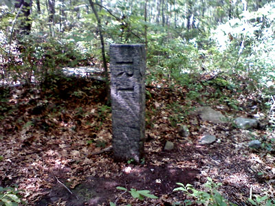A marker along the trail that straddles the Massachusetts-Rhode Island border: the bare ground is in R.I., the rocks are in Mass.